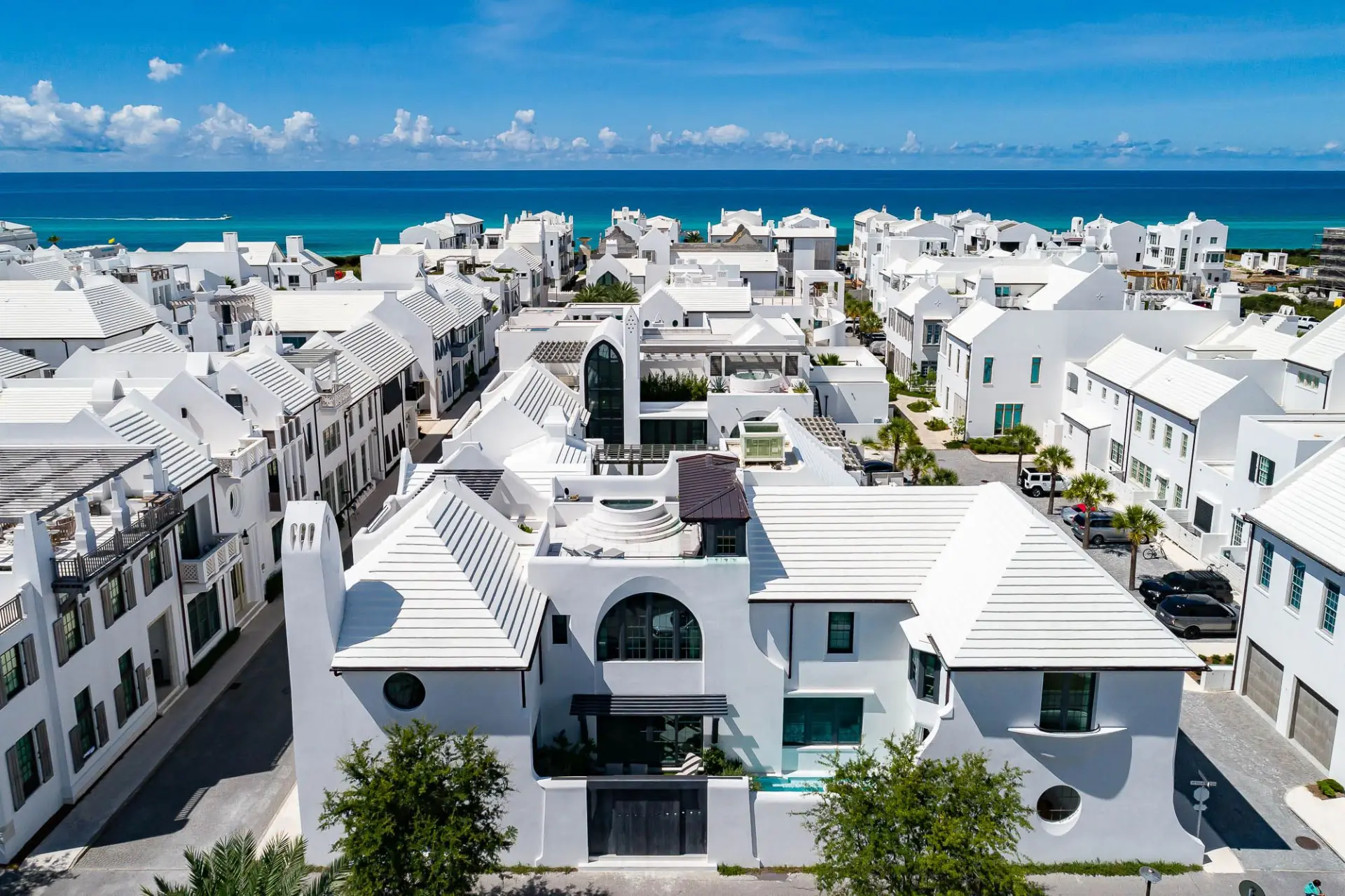Aerial view of Alys Beach white architecture and rooftops with turquoise Gulf water in the background, 30A, FL