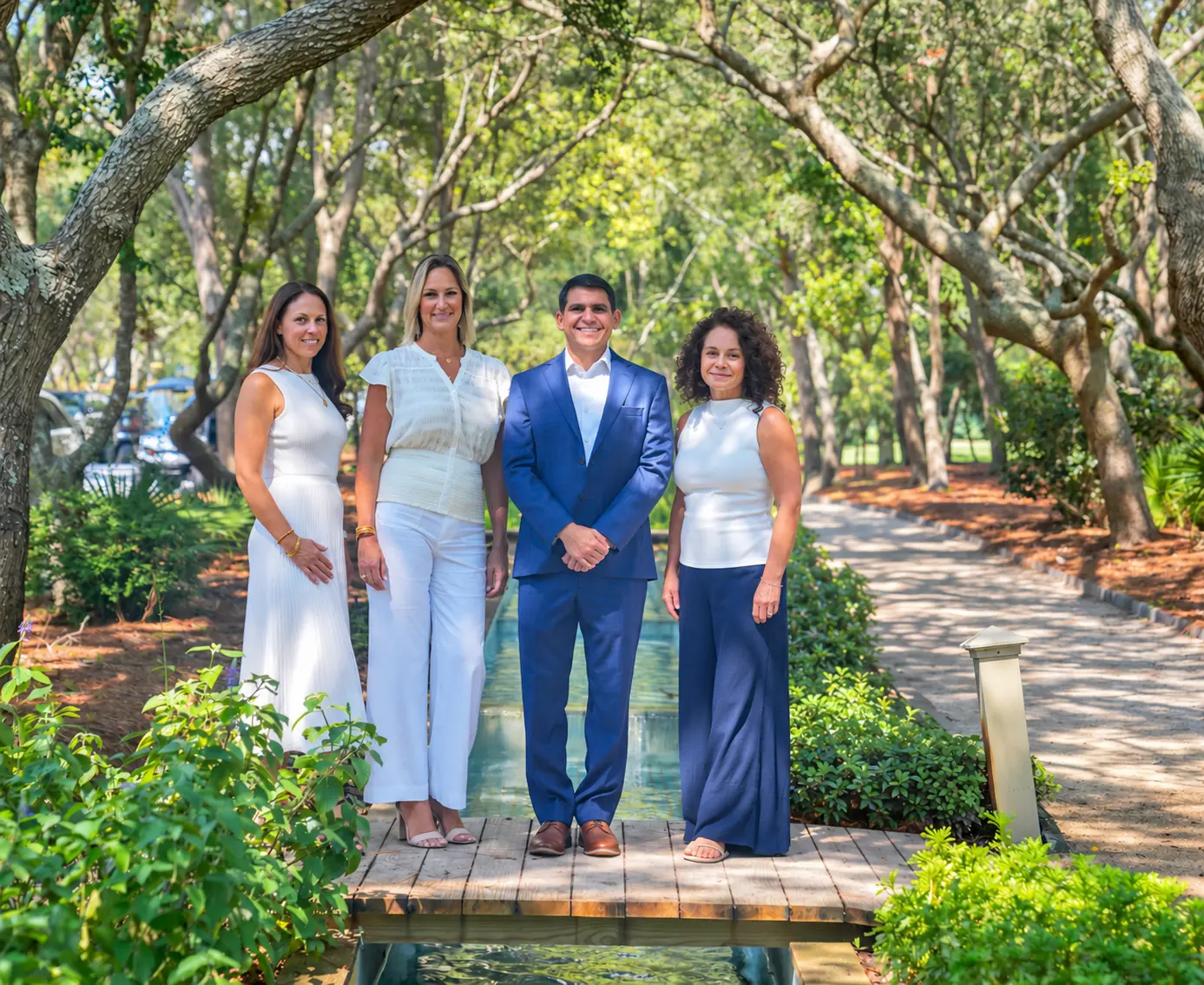 The Jonathan Hill Team of Legacy Hill Real Estate on a garden footbridge in Santa Rosa Beach, Florida